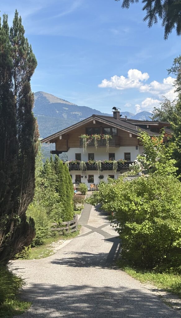 A typical wooden Austrian style house within the Hallein valley. It is surrounded by trees and the balconies are filled with trailing alpine flowers.